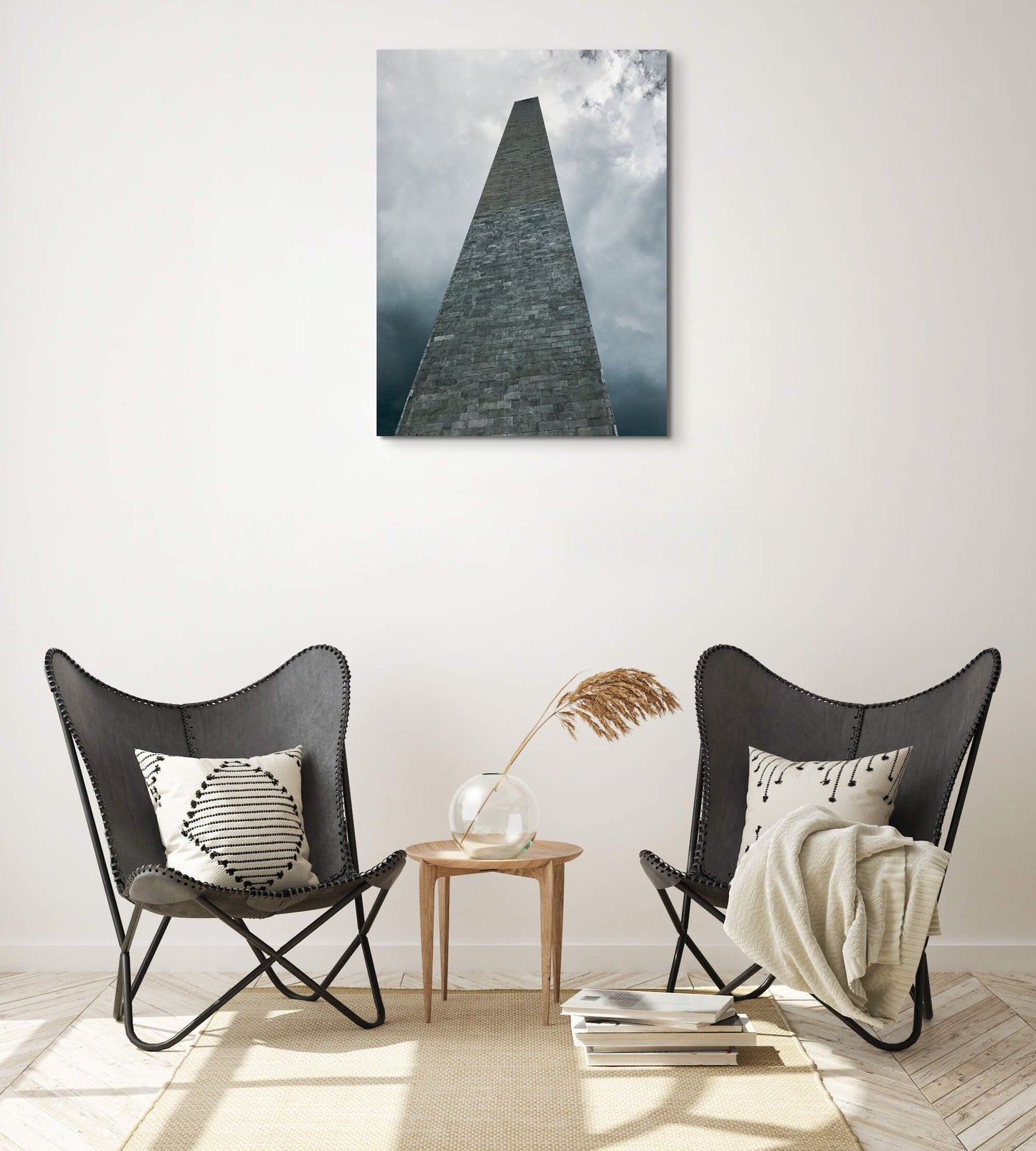Washington Monument Canvas Wall Art in lounge room with white wall, two black chairs, brown rug, two cream cushions, cream blanket and wooden floorboards