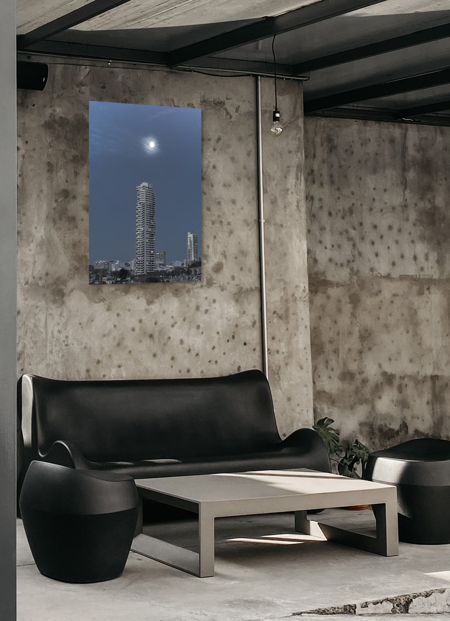 Cityscape at Night Canvas Wall Art in outdoor setting with grey concrete walls and black lounge and chairs