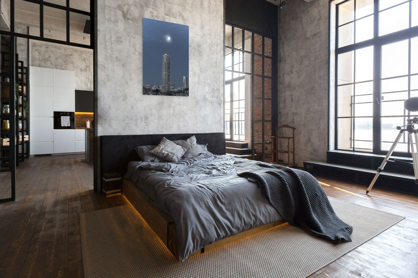 Cityscape at Night Canvas Wall Art in loft style bedroom with grey concrete walls, dark grey quilt and pillows and a telescope