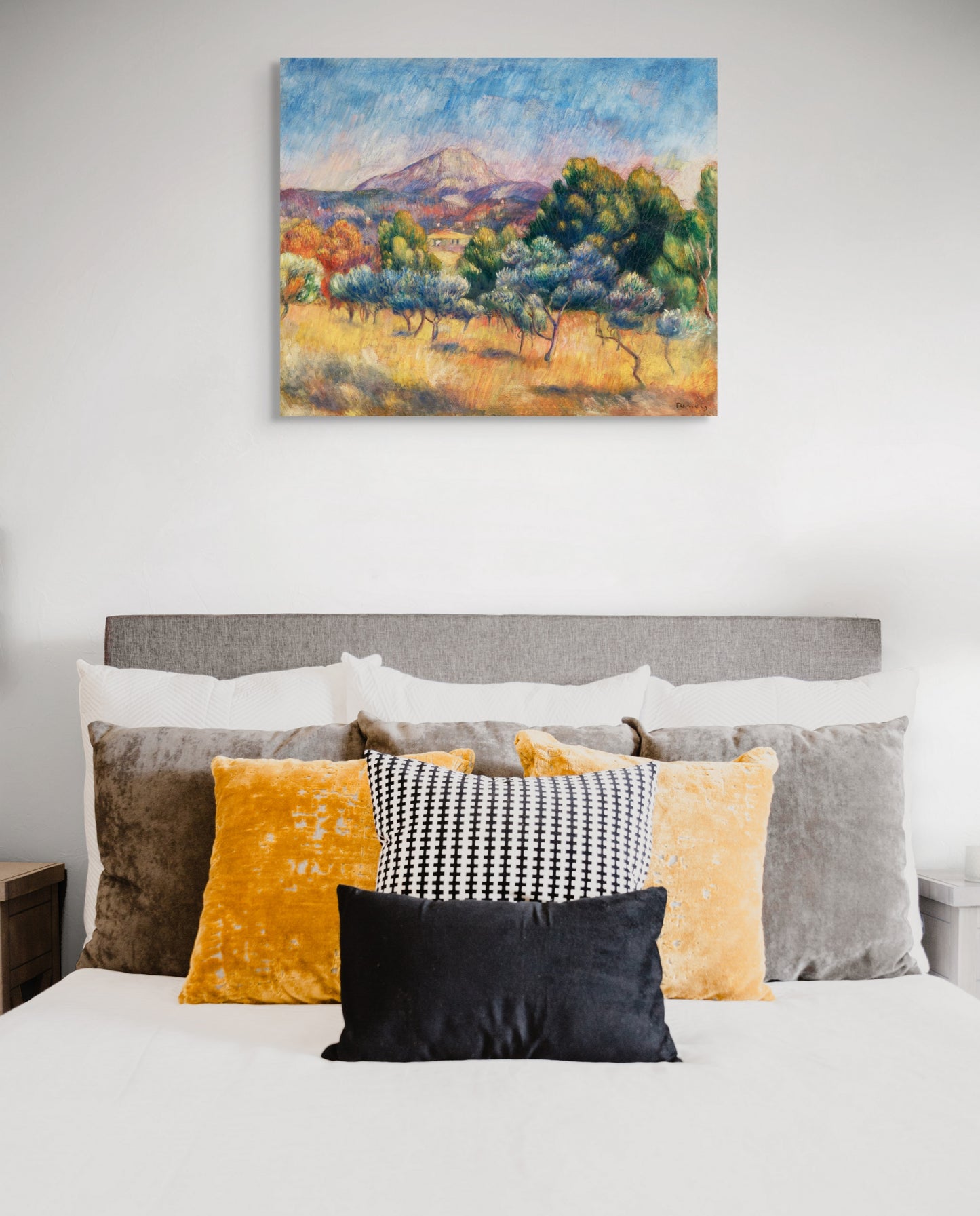 a bed with a painting hanging above it