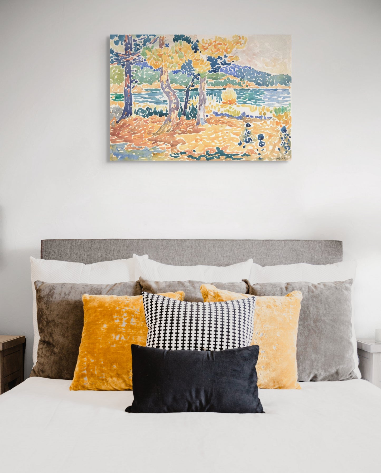 a bed with a painting on the wall above it