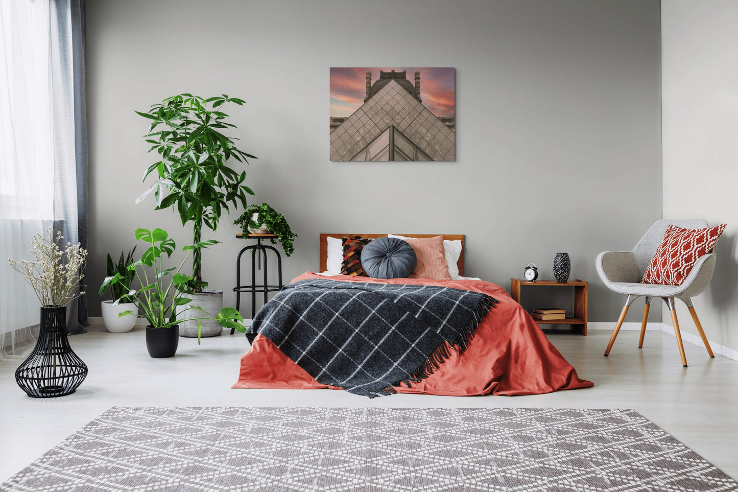 Louvre Museum Canvas Wall Art in bedroom with grey walls, orange quilt, grey chair and several pot plants