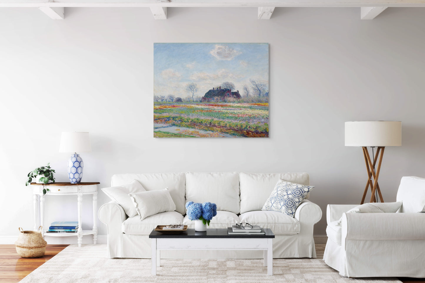 a living room with white furniture and a painting on the wall