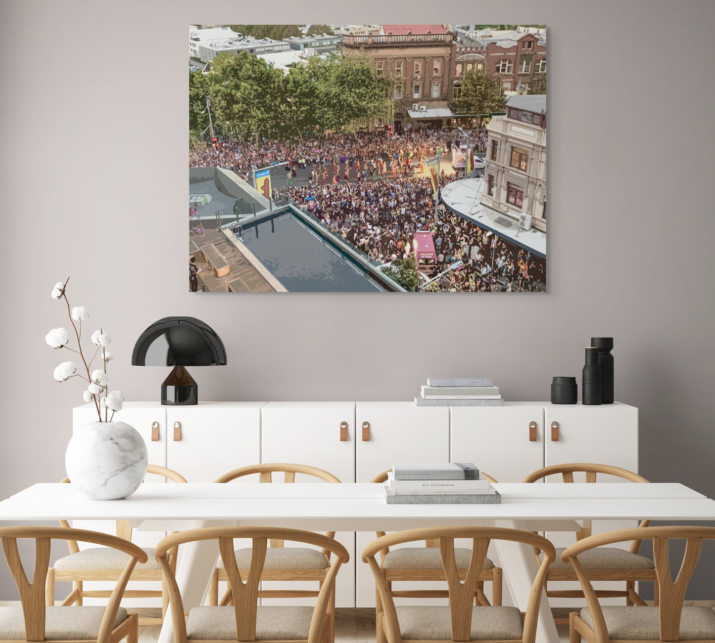 Mardi Gras Canvas Wall Art in dining room with grey wall, white dining table, eight brown wooden chairs and a black lamp
