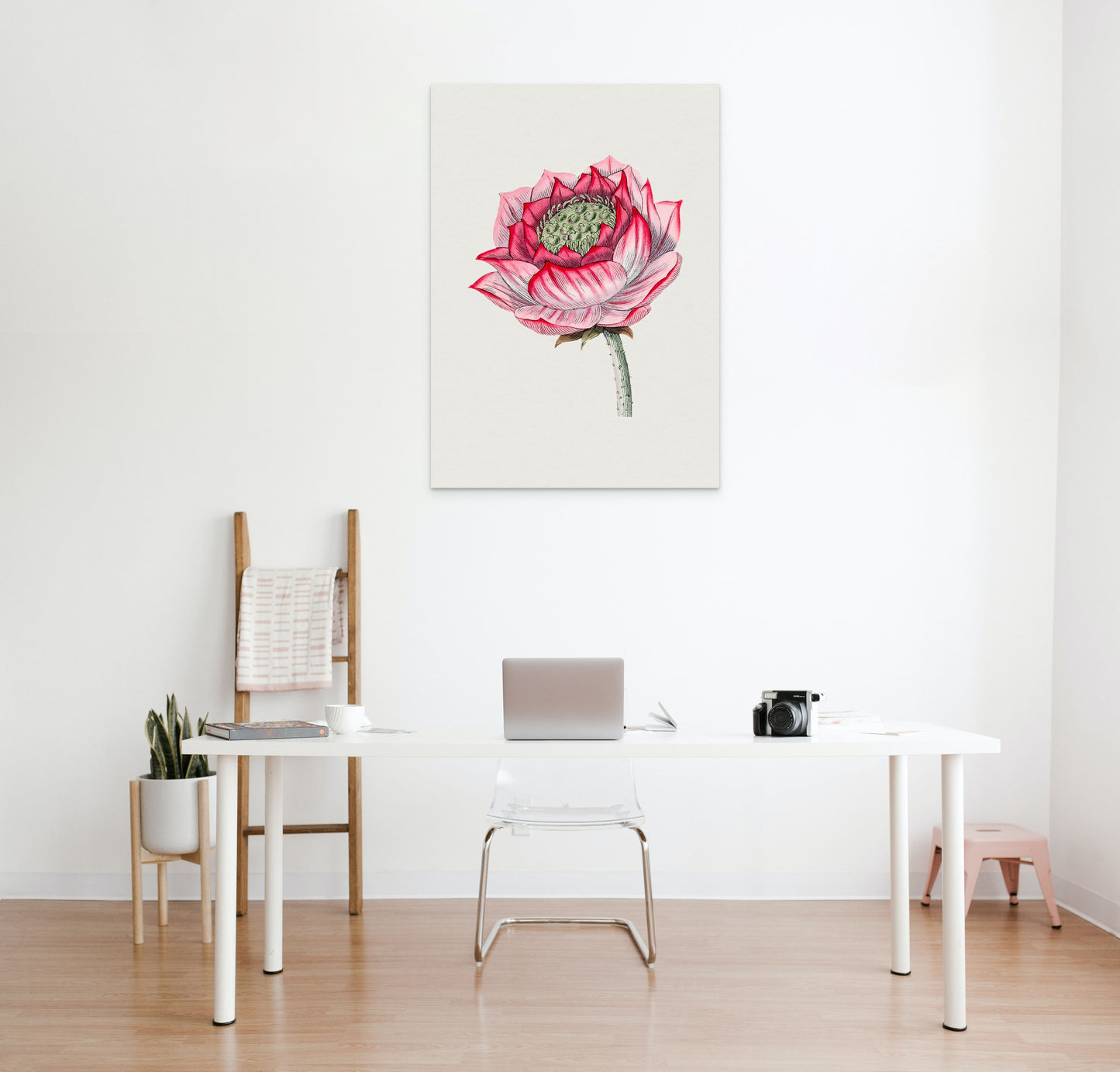 a white table with a laptop and a pink flower on it