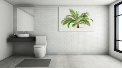a bathroom with a toilet, sink, and a palm tree